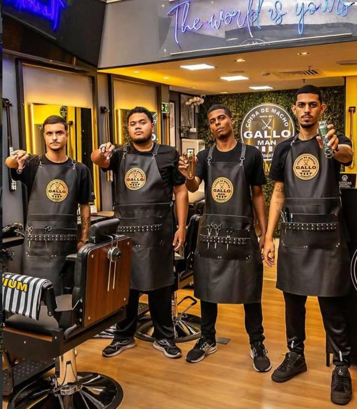 Equipe de barbeiros uniformizada com aventais Gallo Man dentro de uma unidade da rede